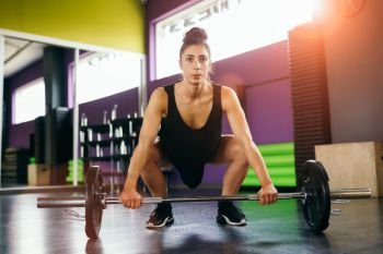Athletic woman in gym lifting weights at the gym. Fitness concept.. Athletic woman in gym lifting weights at the gym