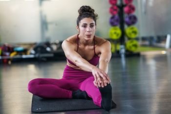 Young woman Doing Stretching Exercises on a yoga mat at the Gym. Young woman Doing Stretching Exercises on a yoga mat