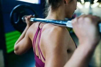Athletic woman in gym lifting weights at the gym. Fitness concept.. Athletic woman in gym lifting weights at the gym