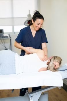 Female Physiotherapist inspecting her patient. Medical check in a physiotherapy center.. Physiotherapist inspecting her patient in a physiotherapy center.