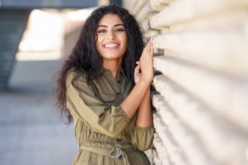 Happy Arab Woman with curly hair in urban background. Young Arab Woman with curly hair outdoors