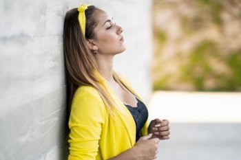 Young woman wearing a yellow jacket and headband outdoors. Young woman wearing a yellow jacket and headband