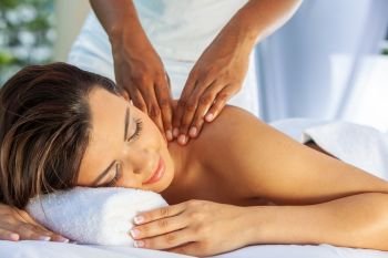 Young woman relaxing at a health spa while having a massage