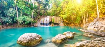 Panorama of tropical landscape with beautiful waterfall, wild rainforest with green foliage and flowing water. Erawan National park, Kanchanaburi, Thailand