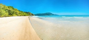 Panorama of beautiful beach at tropical island with white sand and green trees