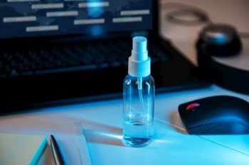 Sanitizer anti virus spray on the working table with laptop. Personal hygiene concept. Concept of quarantine for coronavirus and working from home.. Sanitizer anti virus spray