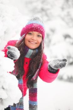 Young cheerful woman play snowballs in winter park. Winter woman play snowballs