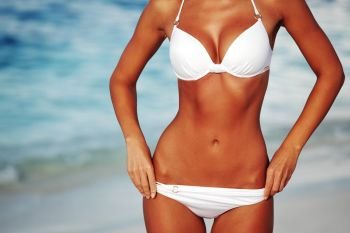 woman tan body in bikini on sea background. woman in bikini