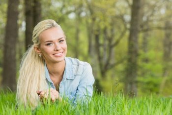 Happy smiling young woman laying on the green grass. woman on the green grass