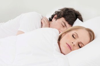 Portrait of couple sleeping in the bed close up focus on woman. Couple sleeping in the bed