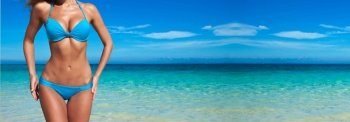 Woman with perfect body in blue bikini over tropical sea background. Woman in bikini over sea