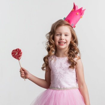 Beautiful little candy princess girl in crown with big pink heart lollipop. Candy princess girl with lollipop