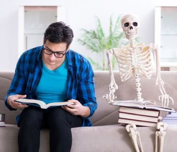 The student studying with skeleton preparing for exams. Student studying with skeleton preparing for exams