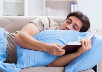 Young student man preparing for college exams in bed with book. The young student man preparing for college exams in bed with bo