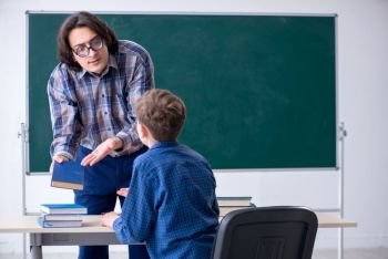 The funny male teacher and boy in the classroom. Funny male teacher and boy in the classroom