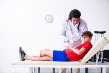 The leg injured boy visiting young doctor traumatologist. Leg injured boy visiting young doctor traumatologist