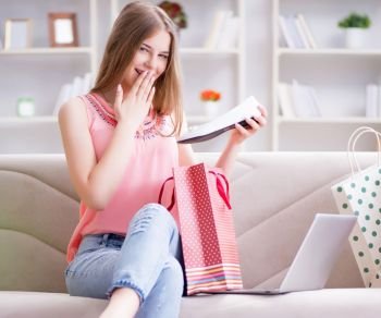 The young woman with shopping bags indoors home on sofa. Young woman with shopping bags indoors home on sofa