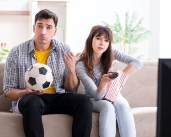 The family pair watching football at home. Family pair watching football at home