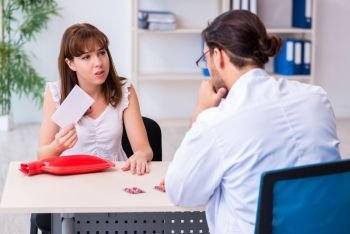The young woman visiting male doctor gastroenterologist. Young woman visiting male doctor gastroenterologist