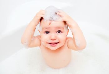 child washing in a bathroom in foam