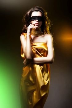 sensual adult woman in golden dress and black mask