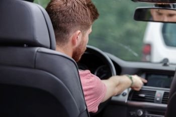 man touching dashboard while sitting in car