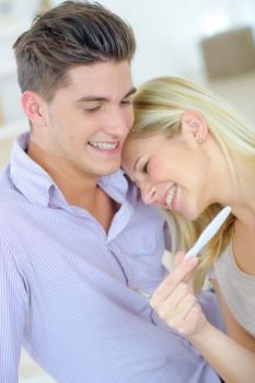 young woman embracing man after positive pregnancy test