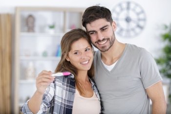 couple showing positive results of pregnancy test