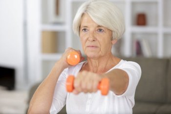 close up of senior woman exercising with dumbbell