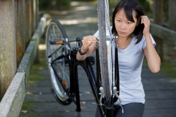 woman attempting to repair her bicycle wheel