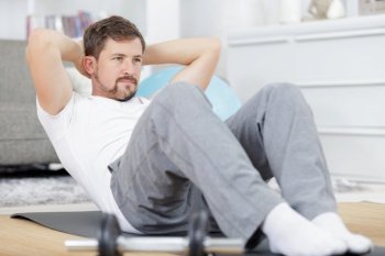 man doing ab training and crunches in living room gym