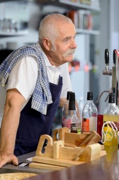 senior bartender serving wine to customers at counter