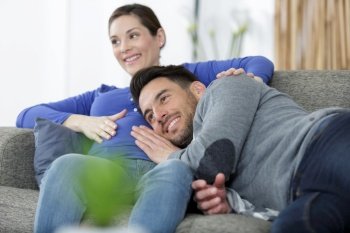 happy man touching belly of smiling pregnant woman