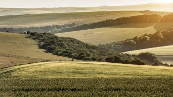 Beautiful late Summer afternoon light over rolling hills in English countryside landscape with vibrant warm light
