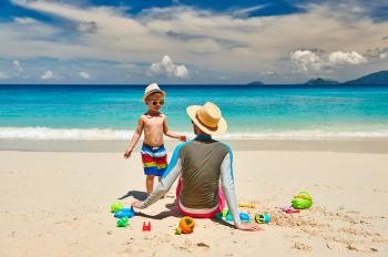 Three year old toddler boy on beach with father. Summer family vacation at at Seychelles, Mahe.