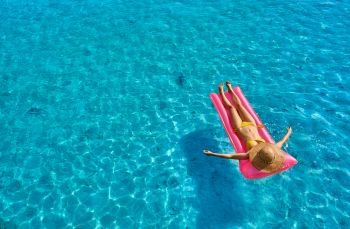 Woman relaxing on inflatable mat float at the beach
