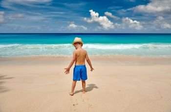 Three year old toddler boy walking on beach. Summer family vacation at Seychelles, Mahe.