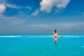Woman relaxing in infinity swimming pool at Maldives