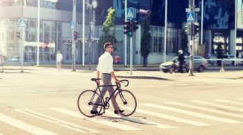 people, style and lifestyle concept - young man with bicycle crossing crosswalk on city street. young man with bicycle on crosswalk in city