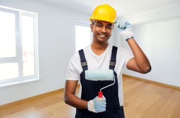 repair, construction and building concept - happy smiling indian builder or painter in helmet with paint roller over empty room background. happy indian painter or builder with paint roller