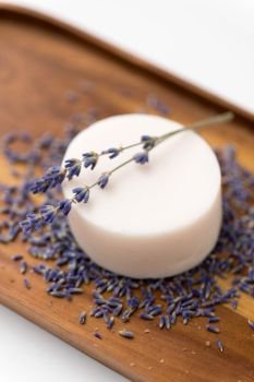 beauty, spa and wellness concept - close up of crafted lavender soap on wooden tray. close up of crafted lavender soap on wooden tray