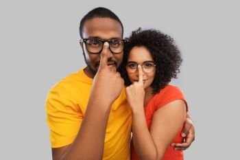 relationships, vision and people concept - happy african american couple in glasses hugging over grey background. happy african american couple in glasses hugging