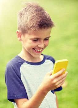 childhood, augmented reality, technology and people concept - happy smiling boy with smartphone playing game in summer park. boy with smartphone playing game in summer park
