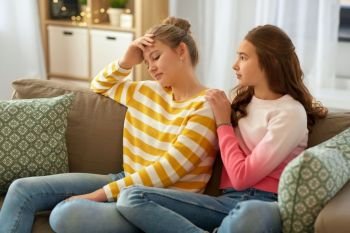 friendship, support and people concept - teenage girl comforting her sad friend at home. teenage girl comforting her sad friend at home