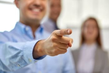 business, gesture and people concept - close up of smiling businessman pointing finger. close up of smiling businessman pointing finger