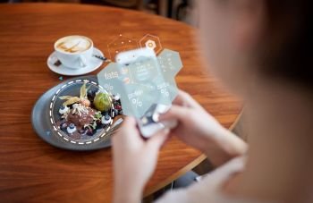 food, new nordic cuisine, technology and people concept - woman with smartphone, chocolate ice cream dessert and nutritional value chart at restaurant. hands with phone and food nutritional value chart