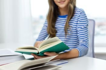 education, school and knowledge concept - close up of student girl with books learning at home. close up of student girl reading books at home