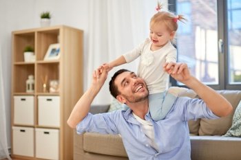 family, parenthood and fatherhood concept - happy father riding little baby daughter on his neck at home. father riding little baby daughter on neck at home