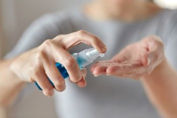 hygiene, health care and safety concept - close up of woman spraying antibacterial hand sanitizer. close up of woman spraying hand sanitizer