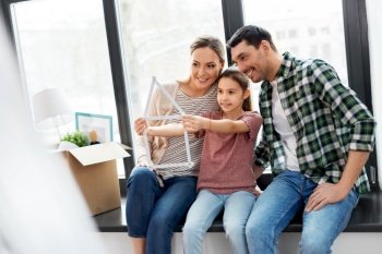 mortgage, family and real estate concept - happy mother, father and little daughter with folding ruler in shape of house and stuff in boxes moving to new home. happy family with folding ruler moving to new home